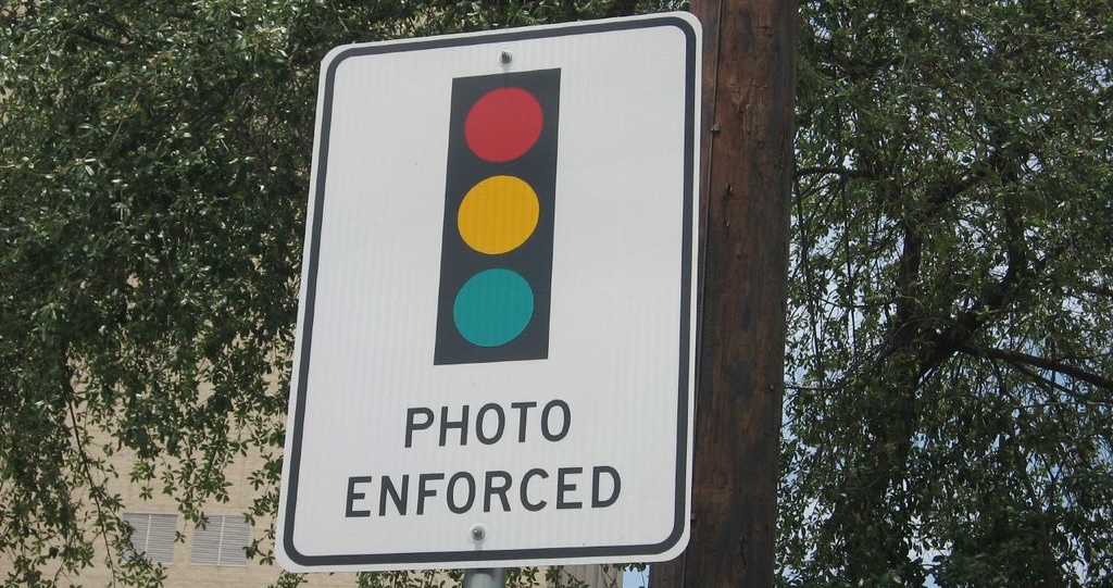 photo of a traffic sign with an illustration of a traffic signal and the words "photo enforced"