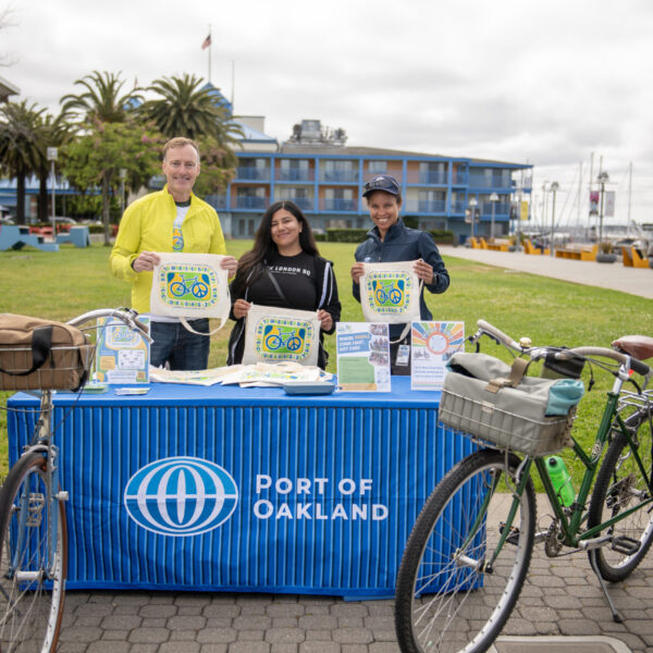Bike to Wherever Day 2024 - the Port of Oakland staff smile and hold up swag at their Energizer Station